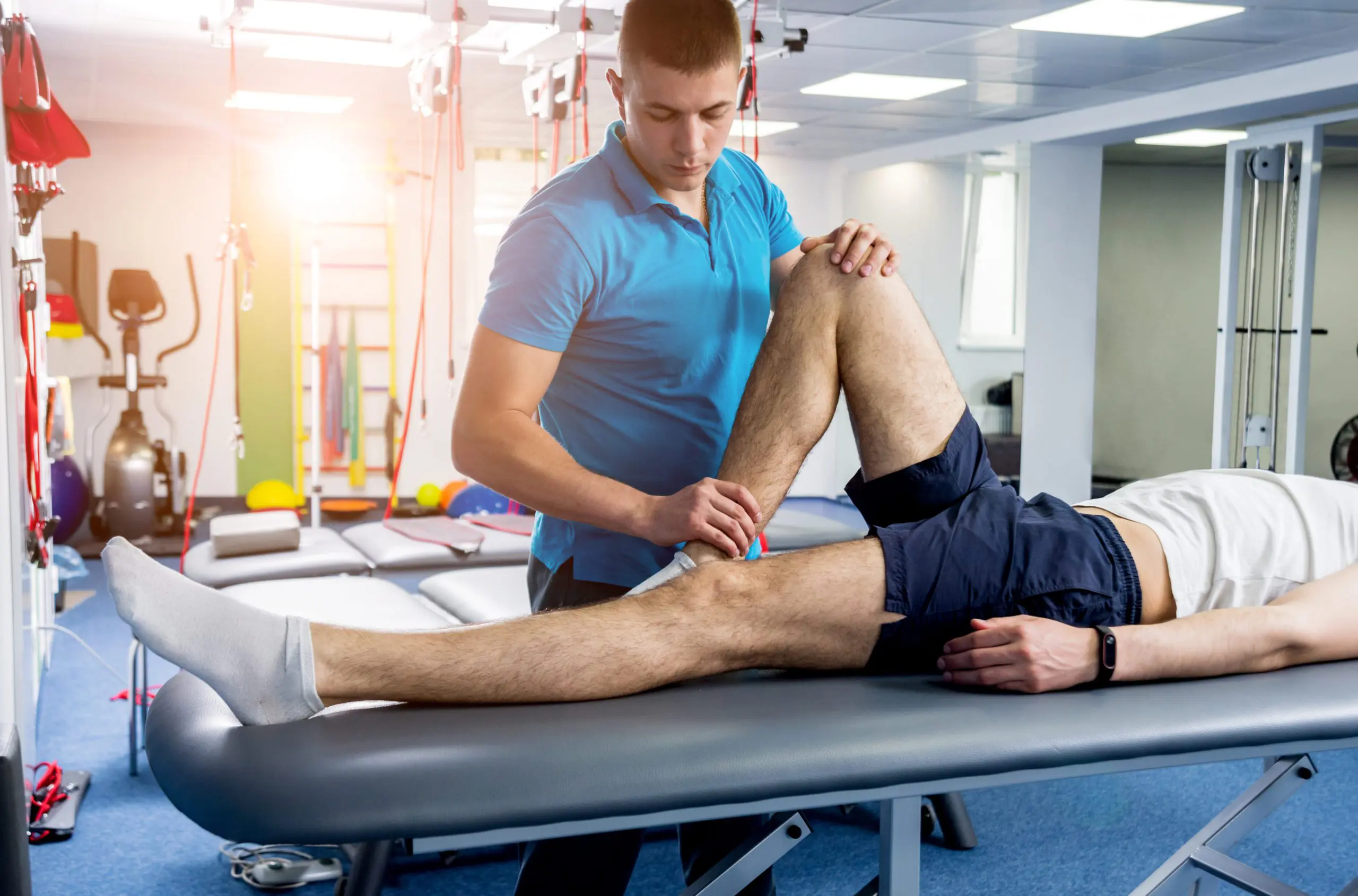 physical therapist stretching a man's knee
