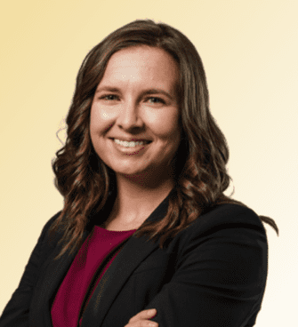 Alanda Weber woman smiling, wearing a maroon shirt and black suit jacket