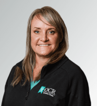 Amy Romero woman smiling, wearing a black jacket and a medical scrubs