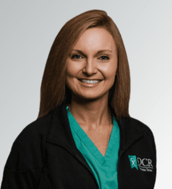 Chelsea Keys woman smiling, wearing a black jacket and a medical scrubs