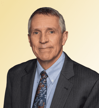 Dale Lehman man smiling, wearing a suit and tie