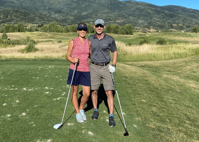 Benz 3 A couple holding golf clubs on a golf course