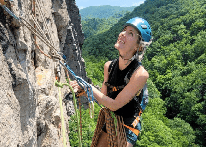 koso rock woman rock climbing with blue helmet
