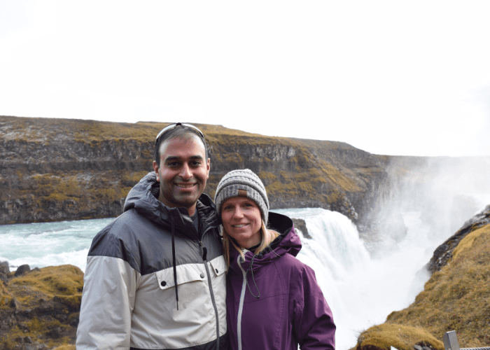 shah 3 A man and a woman standing in front of a waterfall