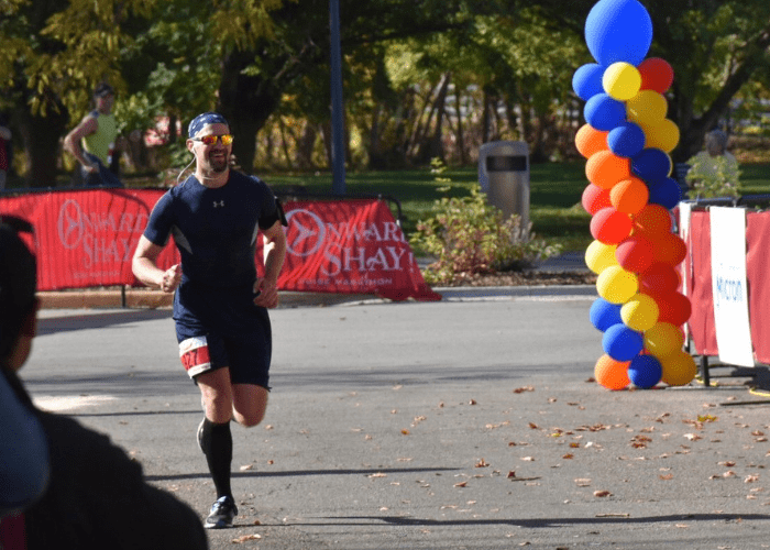 stith 1 man running a race with colorful balloons behind him