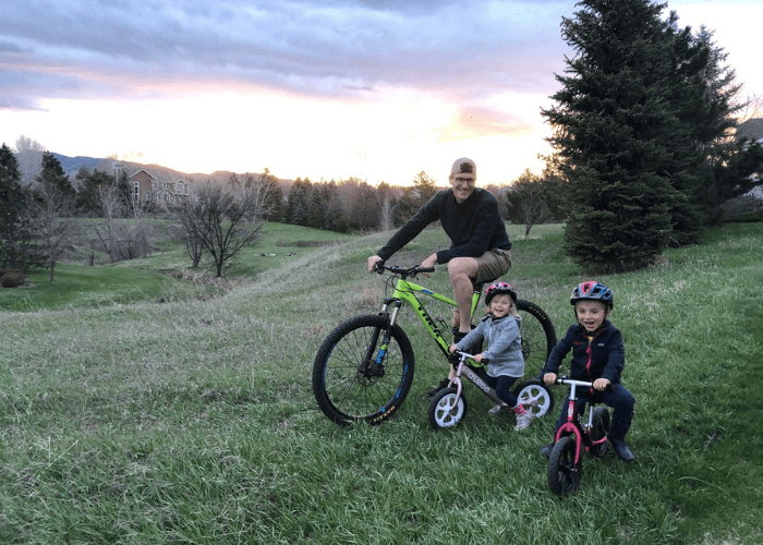 stockburger 2 a man and two kids on bikes with the sunset
