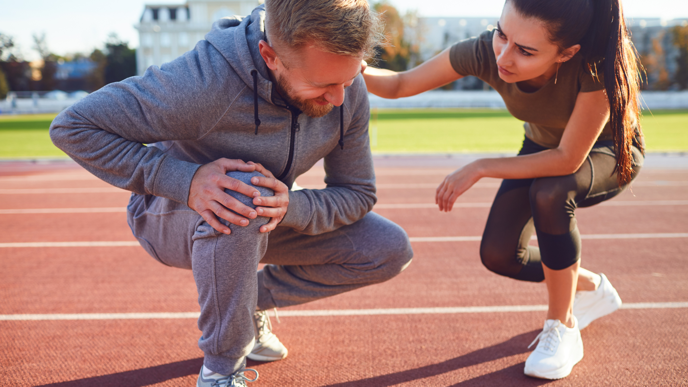 Man crouching down with knee pain without injury getting help from a young woman