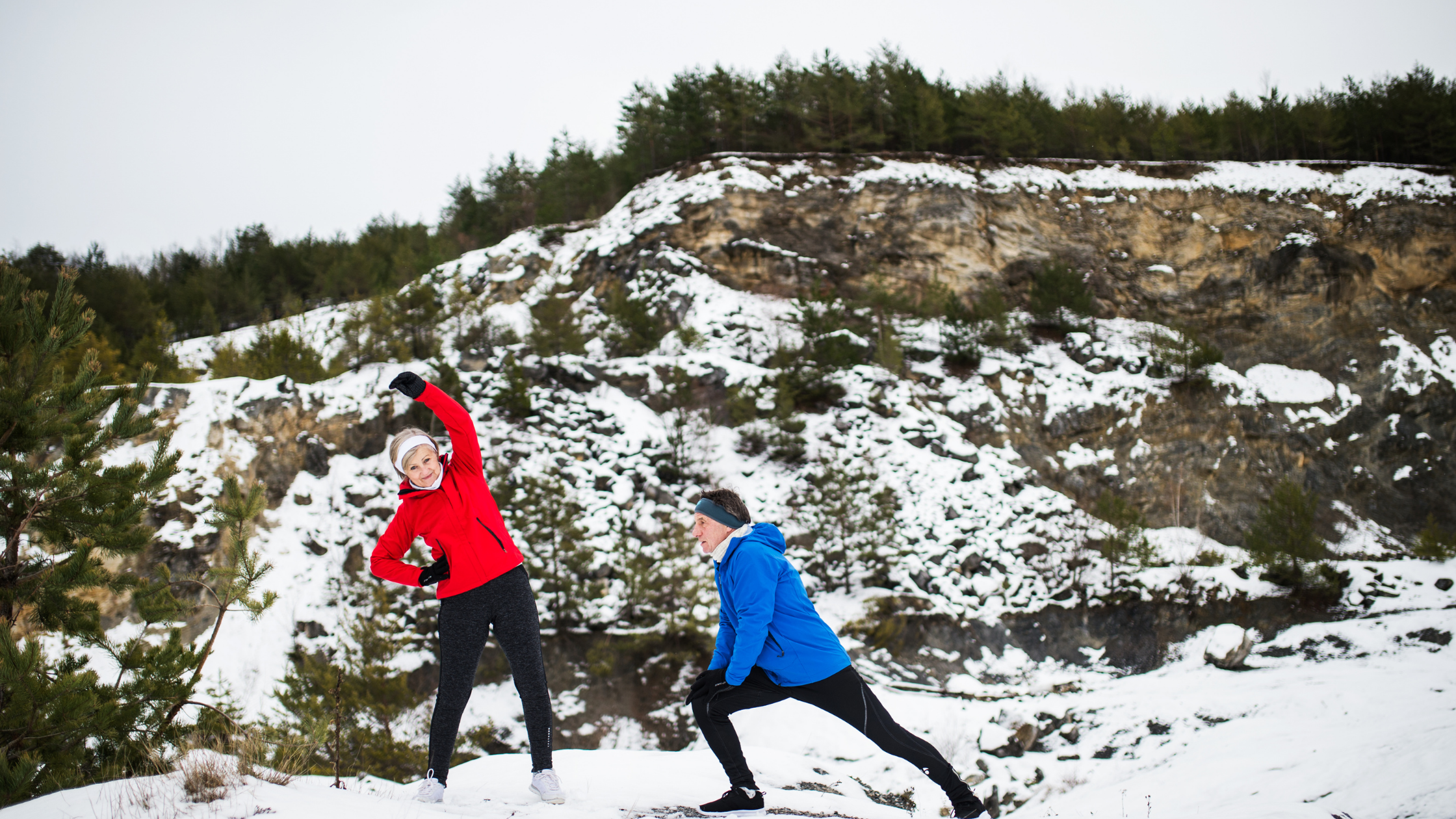 two people stretching in the snow