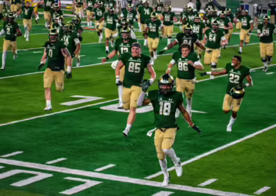 CSU football team running on the field